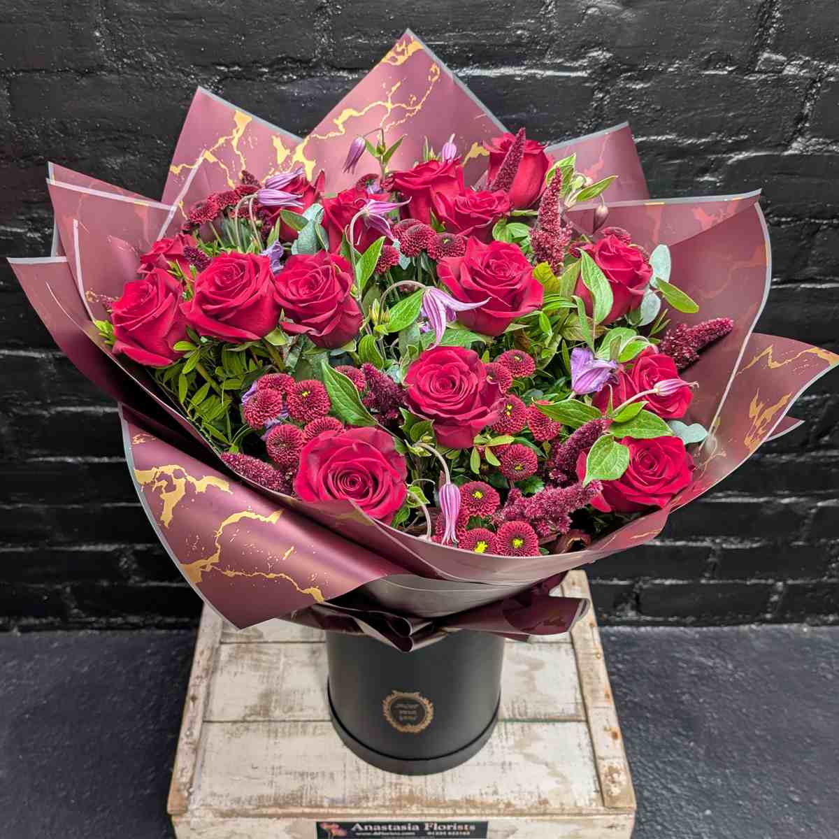 Velvet Night Bouquet of deep red roses and burgundy filler flowers in dark wrapping