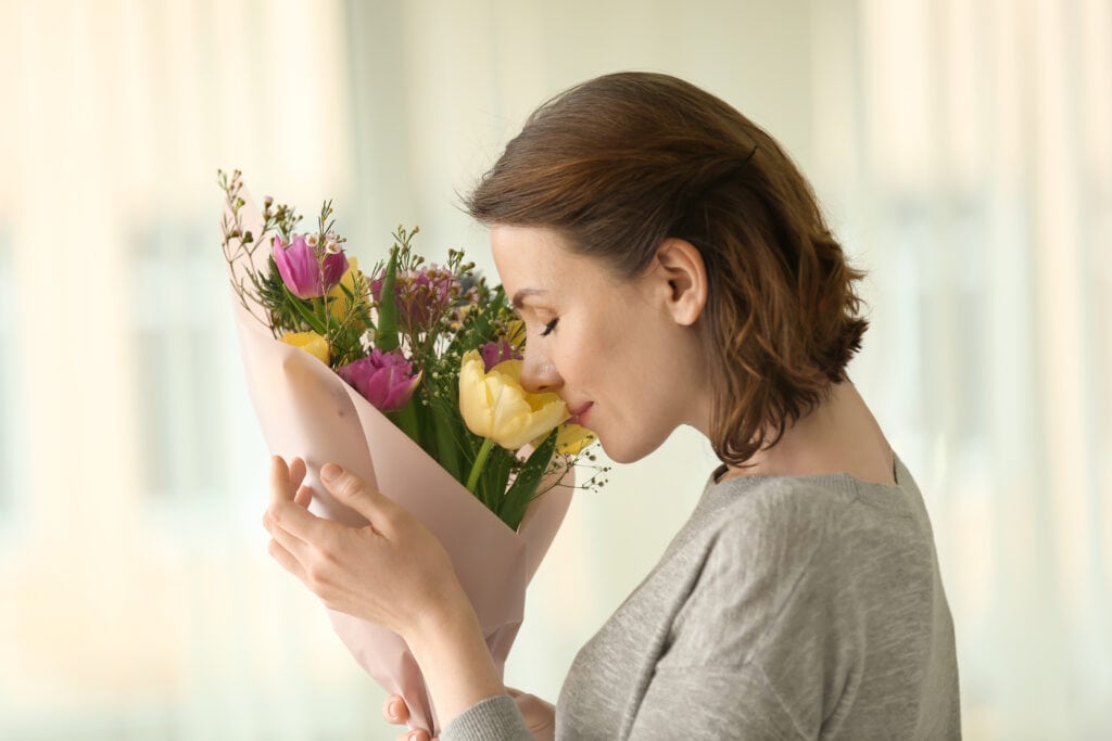 A woman smelling a bouquet of flowers