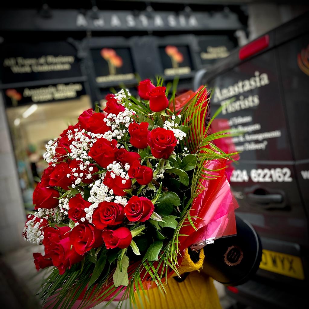 A close-up shot of a red flower bouquet in front of Anastasia Florists