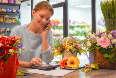 A woman on the phone in a florist shop 