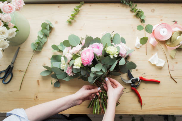 A person arranging flowers and creating a bouquet
