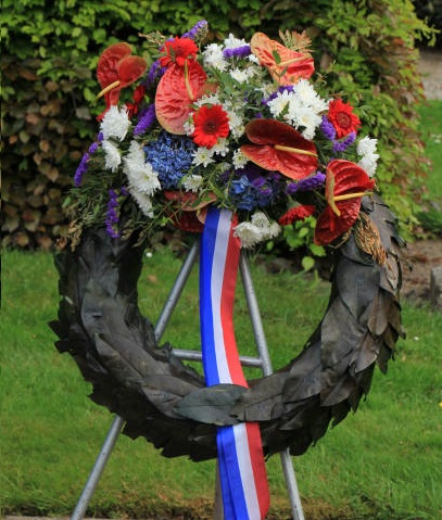 A personalized black funeral wreath with a ribbon